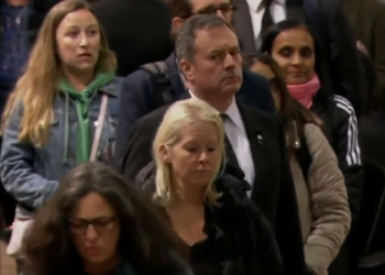 Jason Kenney, working remotely by cellphone from London queue, tweets ostentatiously while waiting to bid farewell to Queen
