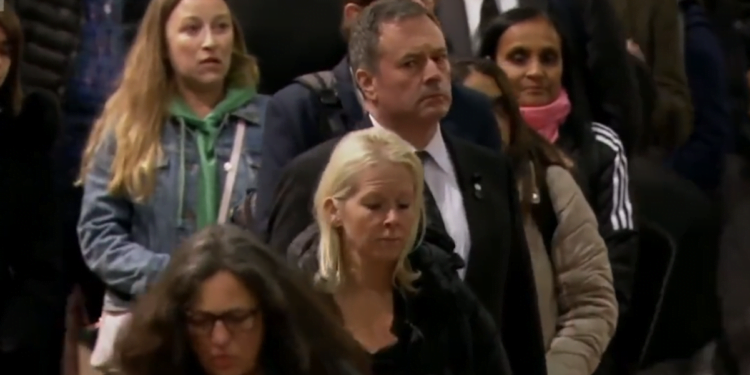Jason Kenney, working remotely by cellphone from London queue, tweets ostentatiously while waiting to bid farewell to Queen