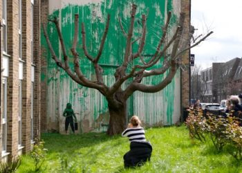 A new Banksy mural sprouts beside a cropped tree in London. Many see an environmental message